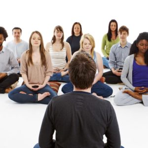 meditation teacher meditating with a group of people